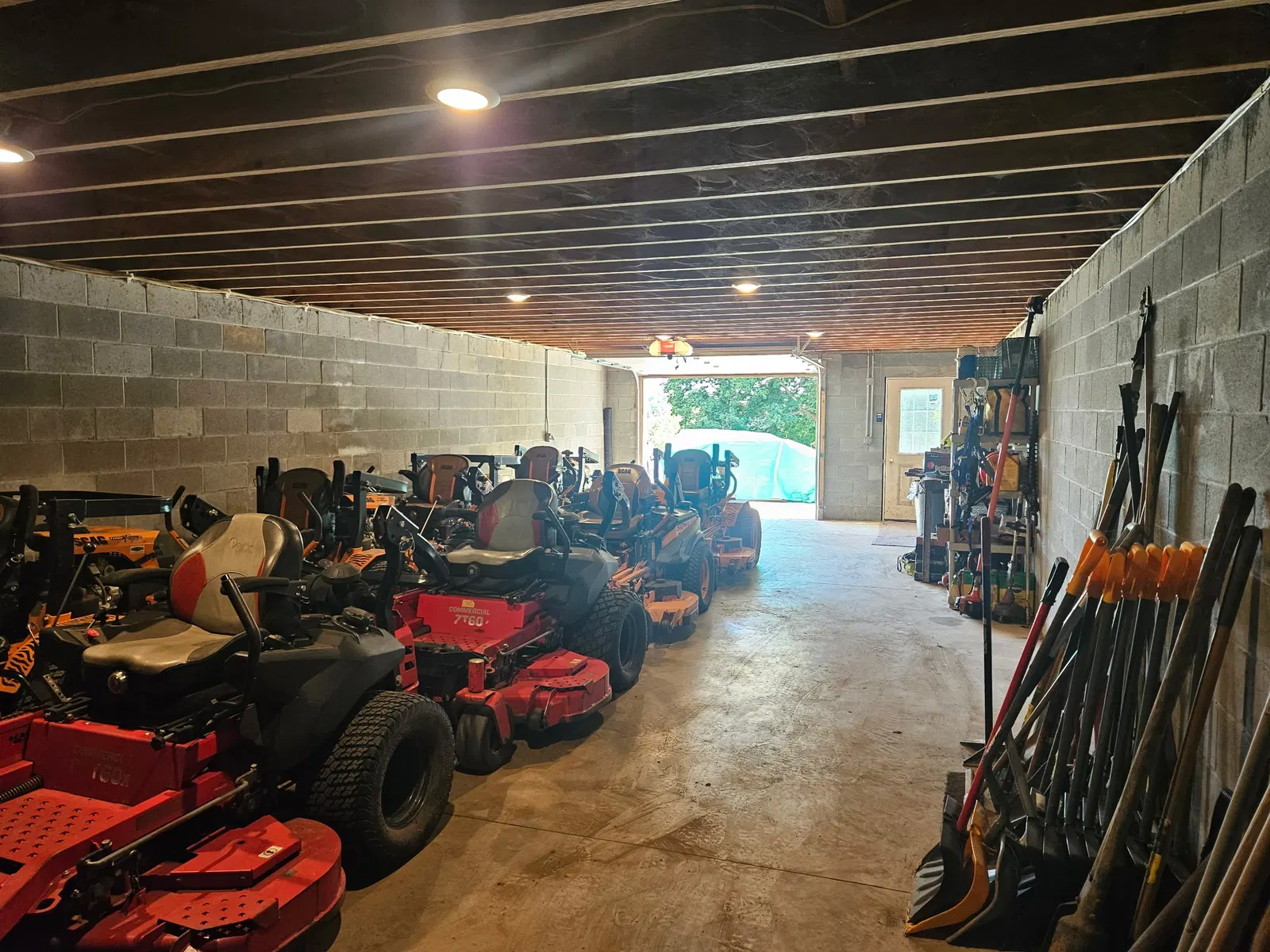 Rows of lawn mowers and property care tools inside the equipment shop
