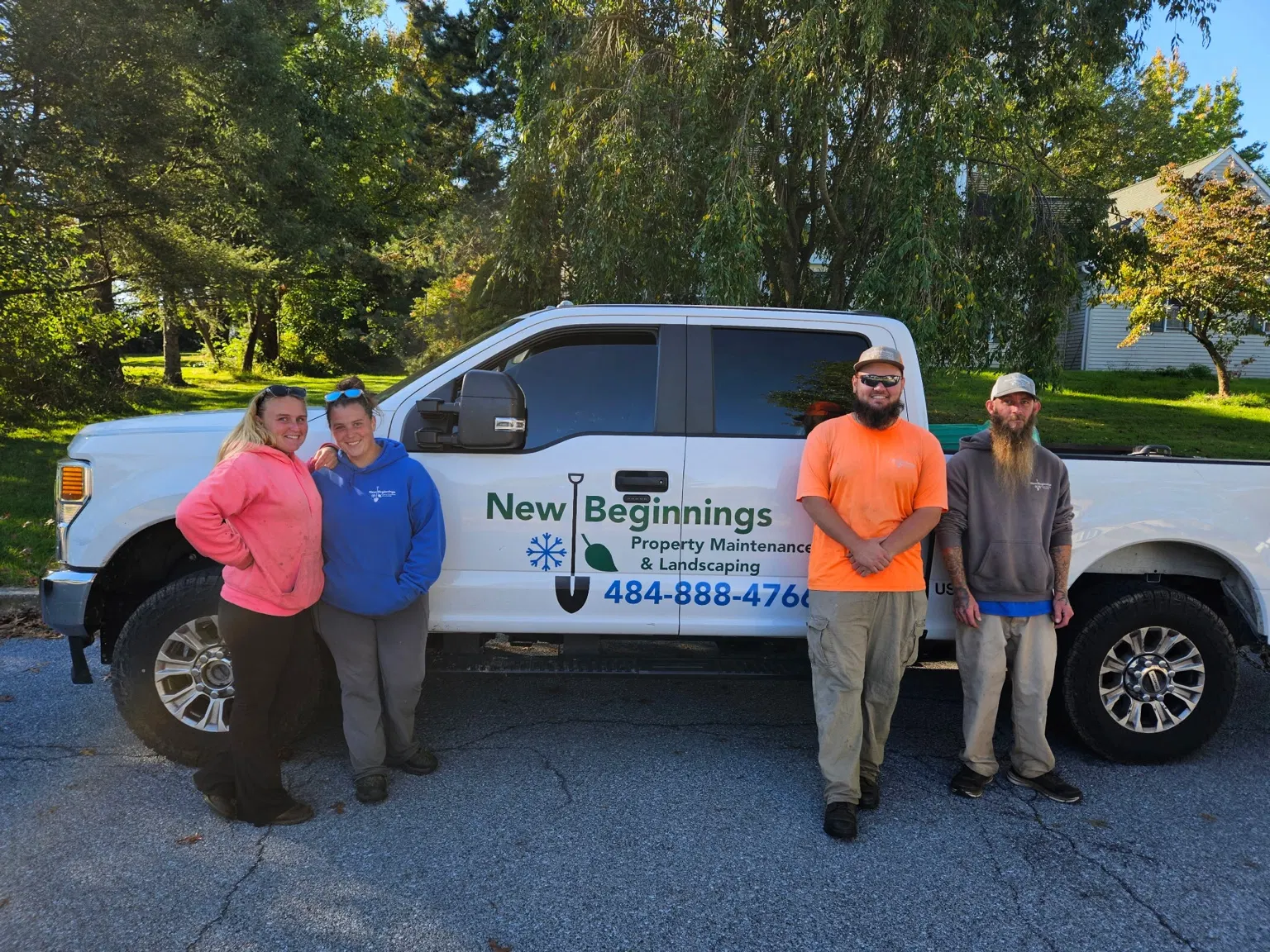 New Beginnings team standing beside the branded company pickup truck