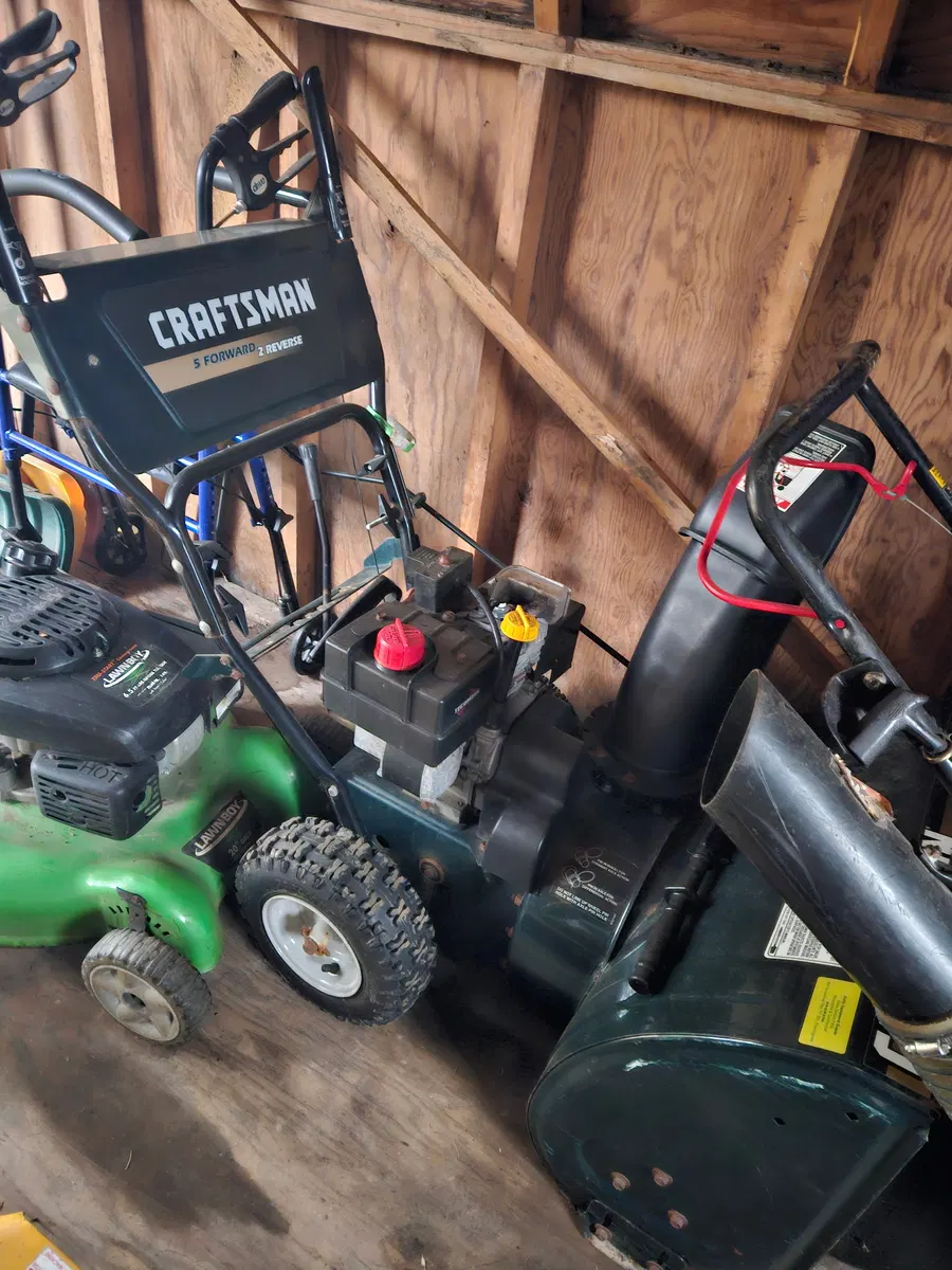 Snowblowers and winter maintenance equipment stored in a shed